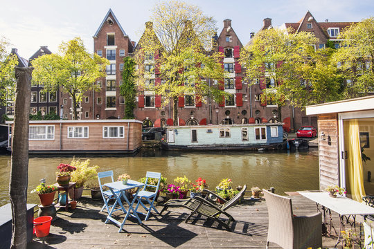 Charming Canal With Boat Houses In Amsterdam Old Town, Netherlands. Popular Travel Destination And Tourist Attraction