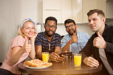 Young friends using phone in kitchen