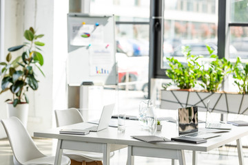 office with table, chairs, green plants and digital devices