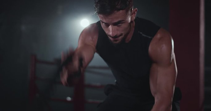 Closeup beautiful athletic guy have a hard workout training practicing cross fitness class he doing exercises with ropes