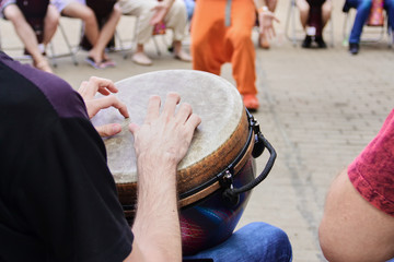 group of people are playing on the African drums