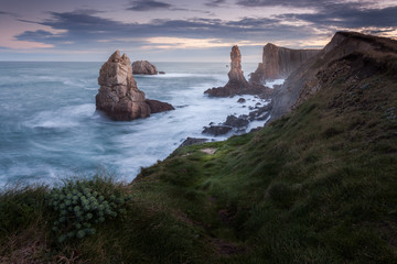 Dark ocean scene at los urros spain. North atlantic waves crushing against harsh cliffs during storm. Dramatic view from top of beach cliff.