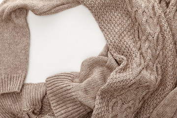 top view of knitted brown sweater on white background with copy space