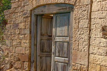 Fototapeta na wymiar Vintage wooden door in abandoned clay arabian house, old building ruins in dagesnta city, russian