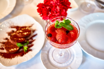 Strawberry dessert with mint is on a glass plate in the restaurant