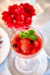 Strawberry dessert with mint is on a glass plate in the restaurant