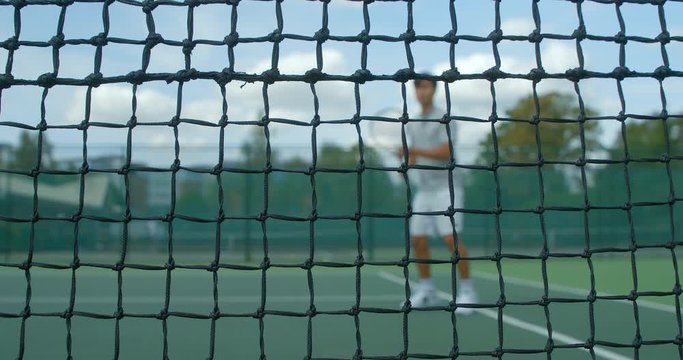 A tennis player hits the net.