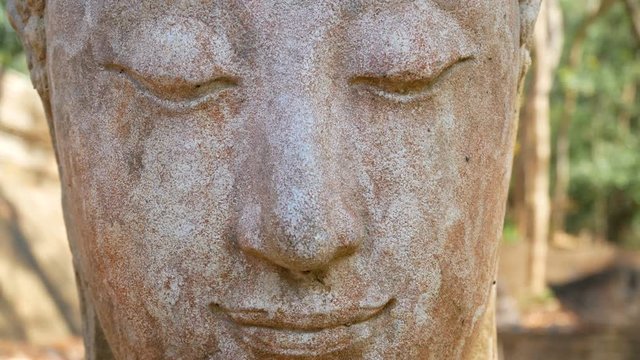 4K. Calm and peaceful face of old worship buddha statue head illuminated. Buddha statue at Chiangmai history temple. Chiang Mai Province, Thailand , Asia