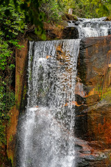 Close up of a waterfall in lush vegetation and red rock formations, Chapada dos Guimarães, Mato Grosso, Brazil, South America