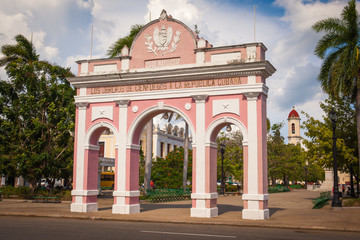 Fototapeta na wymiar View of Jose Marti Park with the Arch of Triumph, the Thomas Terry Theater and the Cathedral of Immaculate Conception in the city center of Cienfuegos, Cuba