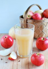 Fresh squeezed apple juice, apple slices, basket with ripe apples on background.