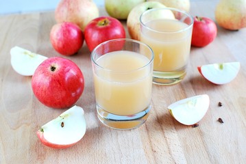 Fresh apple juice on wooden table, ripe apples.