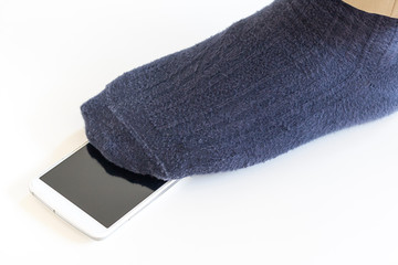 落としたスマートフォンを踏んでいる男性の足