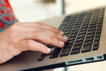 women typing on keyboard of modern laptop 