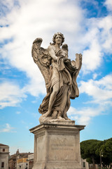 Fototapeta na wymiar Statue of an angel against the blue sky on the bridge of Sant'angelo in Rome, Italy