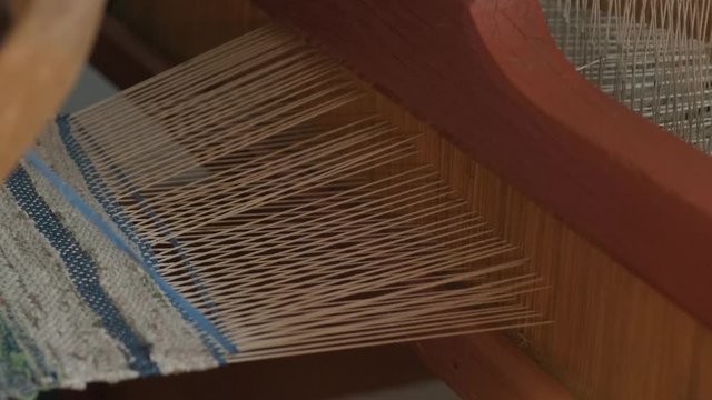 weaver makes fabric in ethnic loom