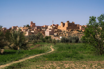 Fototapeta na wymiar View of Tinghir city and a plain green oasis in front of the moroccan traditional village