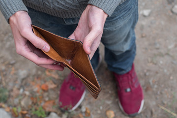 Man holding an empty wallet in street