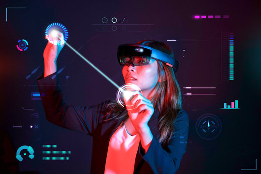 Business woman try vr glasses hololens in the dark room. Young asian girl experience mixed reality. Future technology concept.