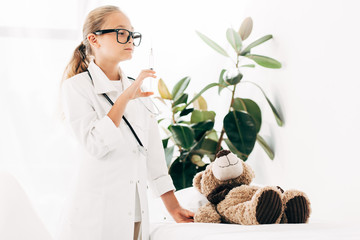 child in doctor costume and glasses holding syringe