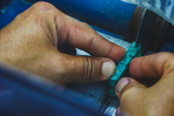 Jewelry technician Cut the Turquoise stone with a stone cutter.
