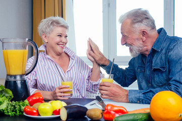 Senior couple drinking vegan smoothie with organic fruits and vegatables from eco glasses and reusable tubes,high five