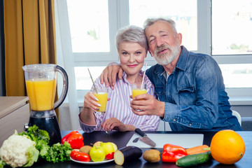 Senior couple drinking vegan smoothie with organic fruits and vegatables from eco glasses and reusable tubes