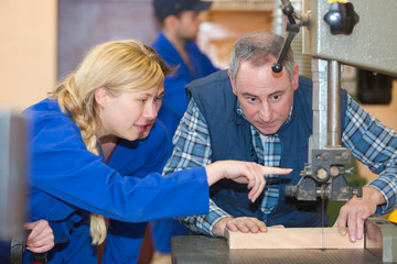 operating drilling machine making furniture in woodworking shop