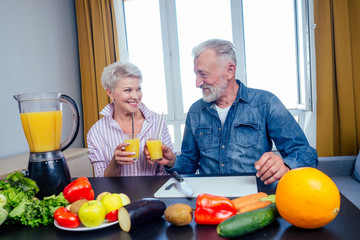 Senior couple drinking vegan smoothie with organic fruits and vegatables from eco glasses and reusable tubes
