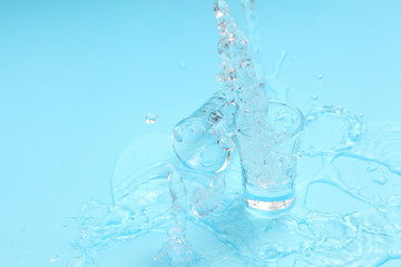 pouring vodka to shot glass on blue background with a blank space for a text, Russian vodka on color table