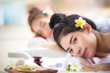 Obraz na płótnie Canvas Two young Asian women relaxing in spa salon. Beauty service with friends on spa bed.