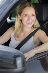 Fototapeta na wymiar beautiful young blond woman driving a car