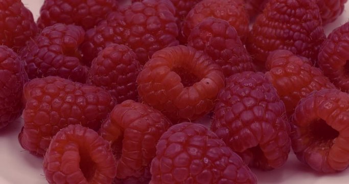 Red raspberry seeds rotation on white background.