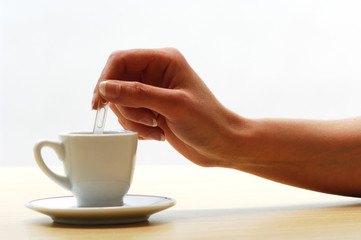 Woman's hand stirring coffee cup
