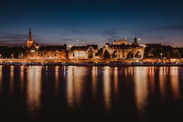 Obraz na płótnie Canvas Szczecin. Night view from across the river to the illuminated historic center. Odra river. Chrobry embankments in Szczecin