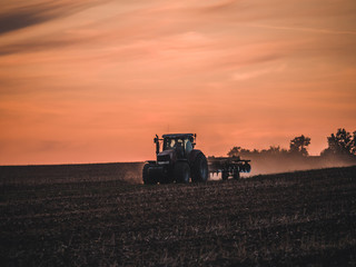 Tractor on filed by sunset.