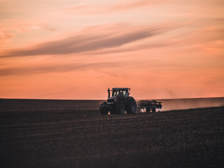 Tractor on filed by sunset.