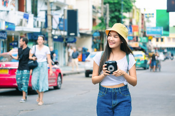 Traveler woman with instant camera in bangkok city