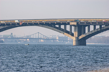 Arch of the Metro bridge (Brovary avenue) over the Dnieper river in Kiev, Ukraine. In background the Pishokhidnyy Mist Cherez Dnipro (Pedestrian bridge across the Dnieper), leading to Hidropark