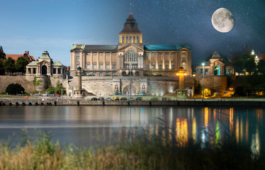 Day and night view from across the river to the illuminated historic center. Odra river. Chrobry embankments in Szczecin