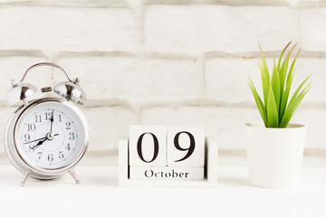 October 9 on the wooden calendar next to the alarm clock, the date of the autumn month