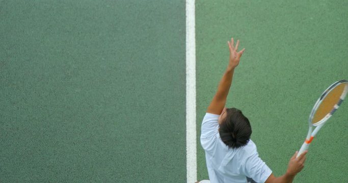 Close up of a tennis player serving in slow motion.