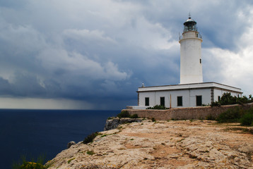 Fototapeta na wymiar Far de la Mola, lighthouse on the cliffs of Formentera an approaching storm.