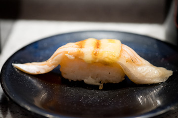 Burn salmon sushi in black plate