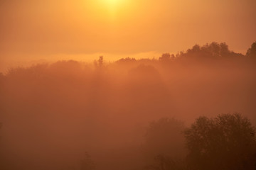The sky at sunrise, dense fog on the meadow in early morning