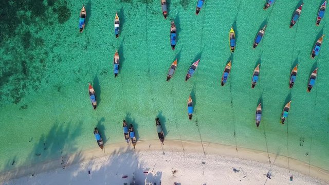 Aerial view, Summer colorful seascape with boats and tropical beach. Beautiful paradise in sandy seaside. Peaceful andaman sea at Koh Lipe, Satun, Thailand. Movement camera is truck.