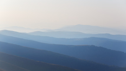 Fototapeta premium beautiful long hills in a blue mist at the early morning, outdoor background