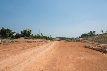 Fototapeta na wymiar Wide dirt level pavement landscape view on outdoor road construction site