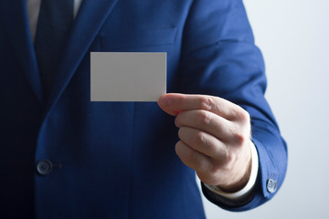 Hand holding white business card on white background