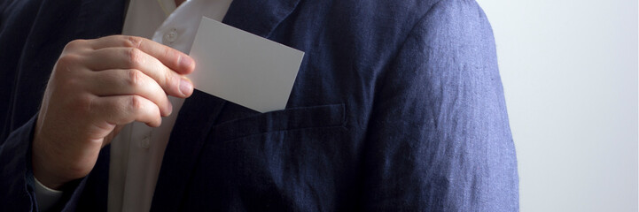 Hand holding white business card on white background